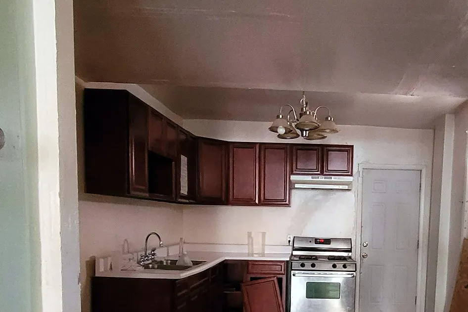 The same kitchen before, with cherry cabinets and an old freestanding range