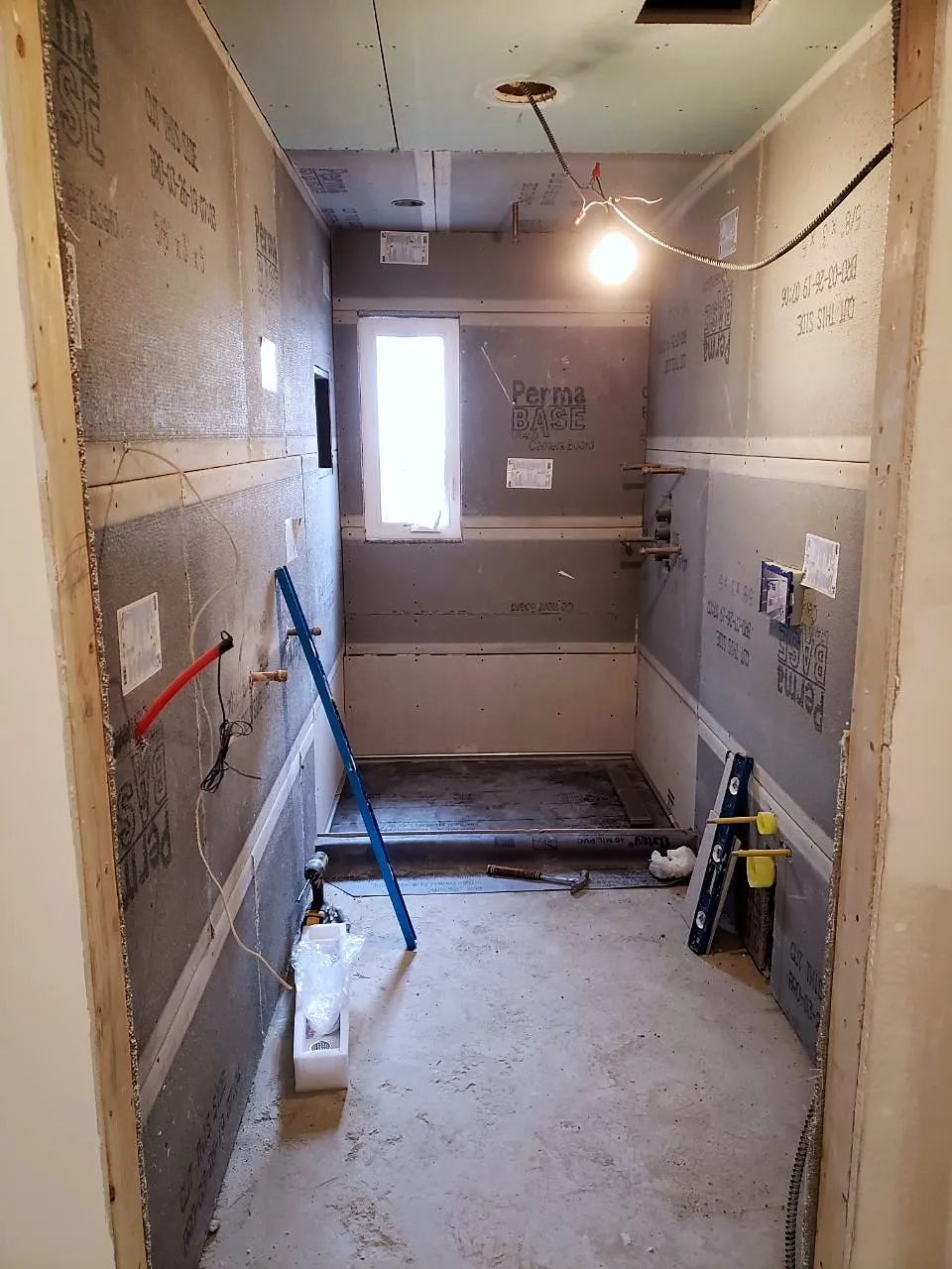 Bathroom with cement board walls, rough plumbing and a new window