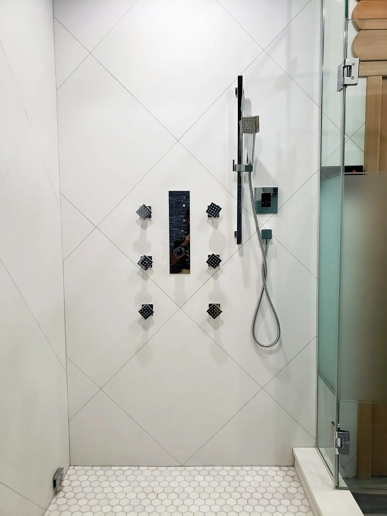 White shower with diagonal tile pattern and black fixtures