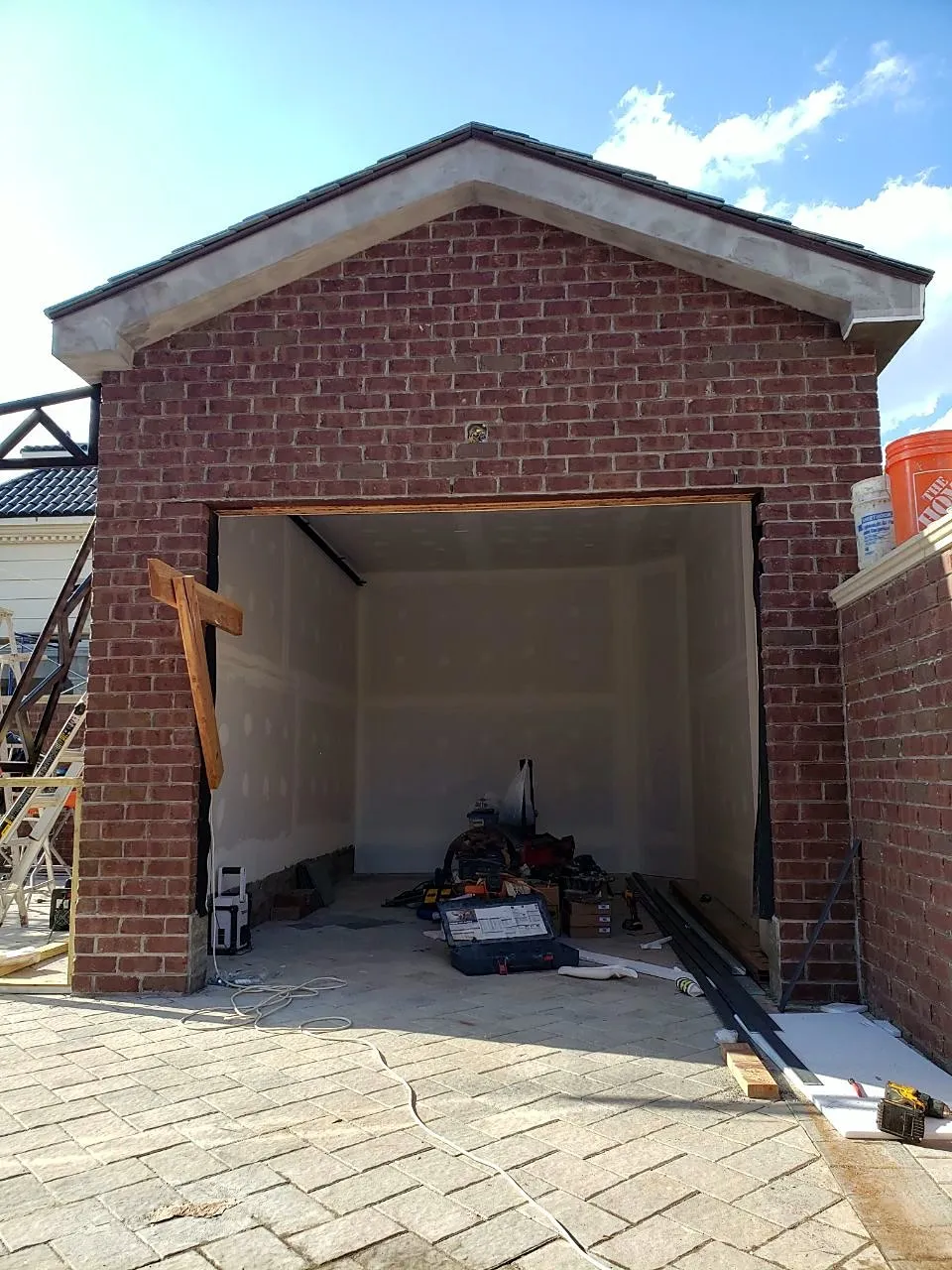 New brick garage with a gabled roof and open door