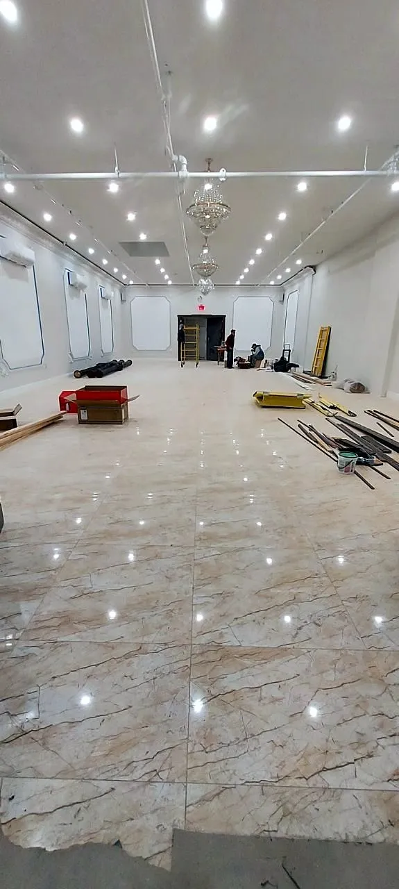 Large open room with a polished marble floor and recessed ceiling lights