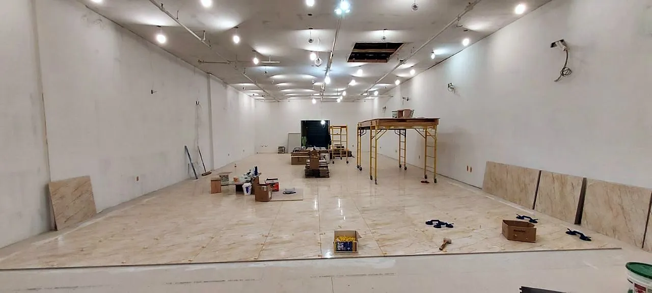 Wide open-plan room with marble floor and finished ceiling during cleanup