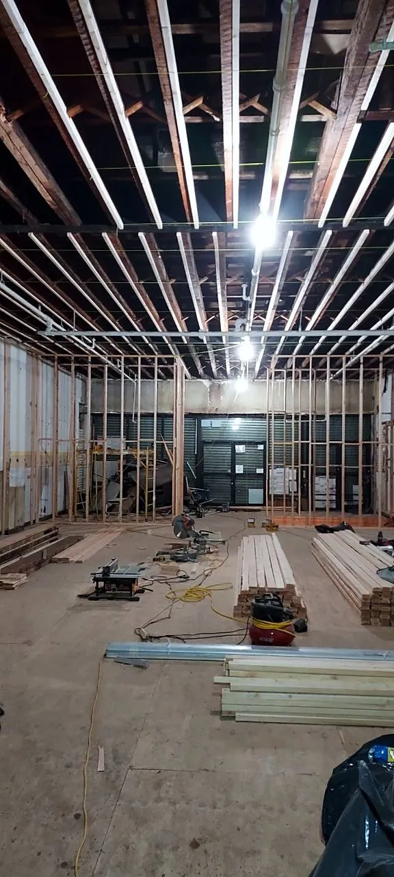 New metal ceiling framing across a long room toward the storefront