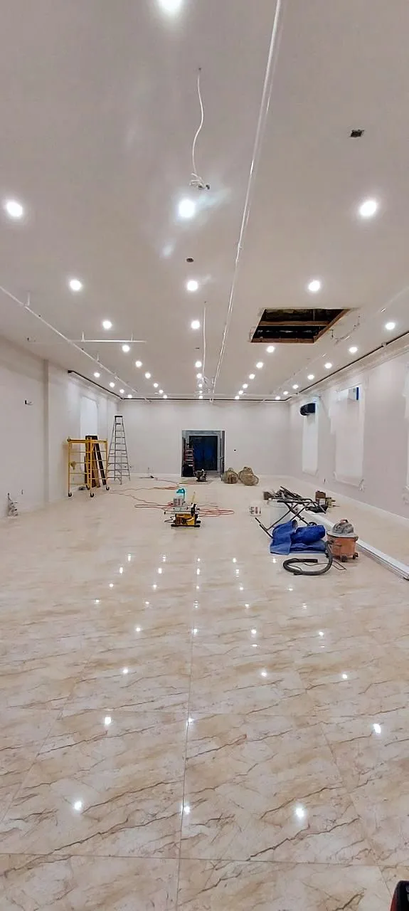 Long room with marble floor and recessed lighting looking toward the exit