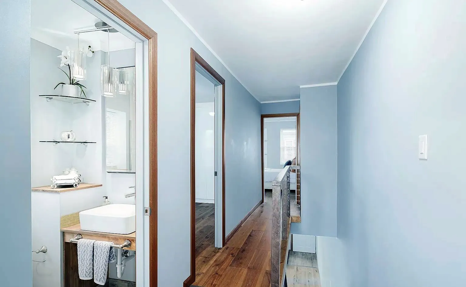 Upstairs hallway with painted walls, crown molding and wood door trim