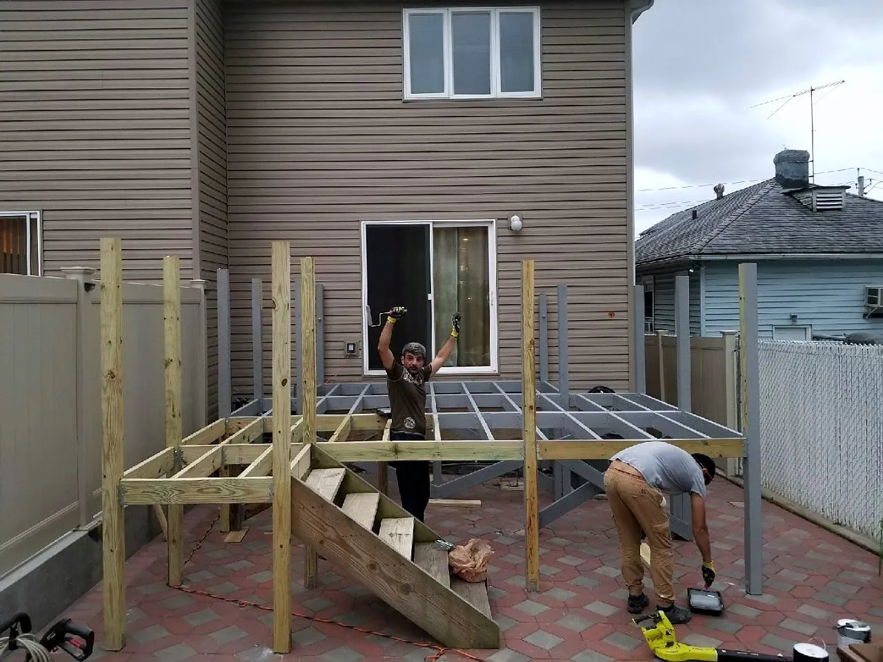 Deck posts and joists going up in a backyard