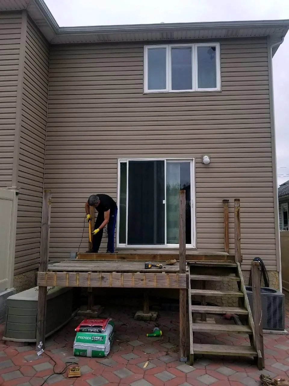 Deck framing and stair stringers under construction against the house
