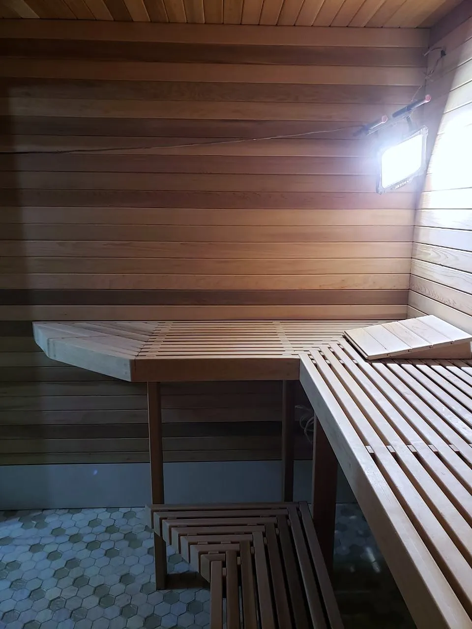 Cedar sauna benches and backrest with a wall light