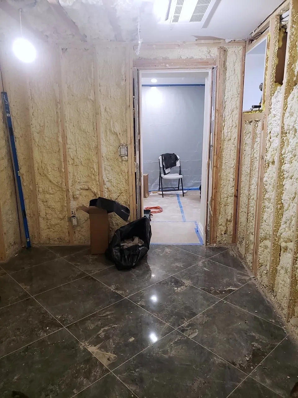 Basement with spray foam insulation and marble floor before the sauna build