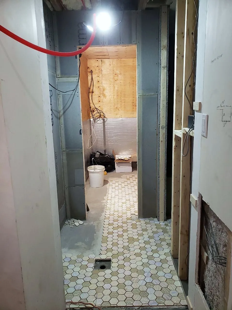 Sauna framing beside a hex tile floor during construction