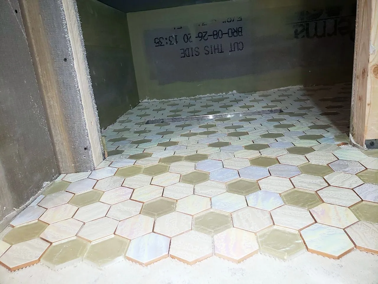 Hexagon floor tile being laid in the basement