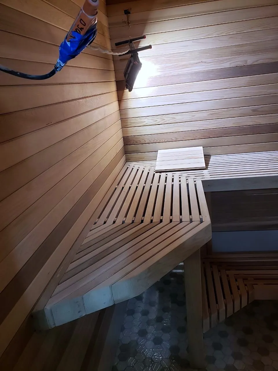 Cedar sauna benches under warm light, built into a Queens basement during the heating season
