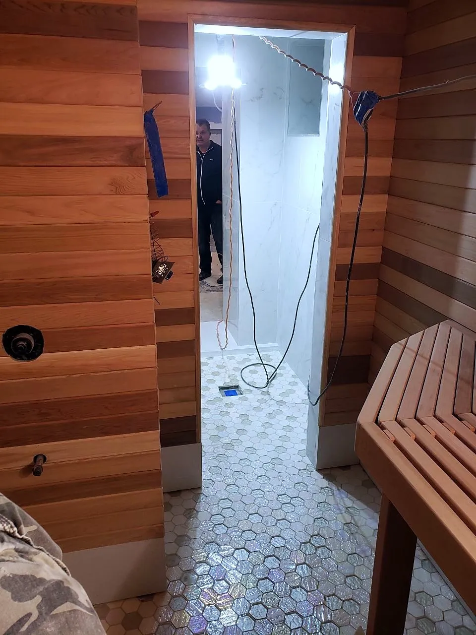 Sauna interior with the door open onto a hex tile floor
